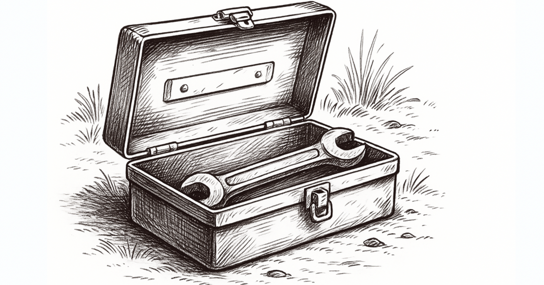 A black and white sketch of an open toolbox with a wrench on top